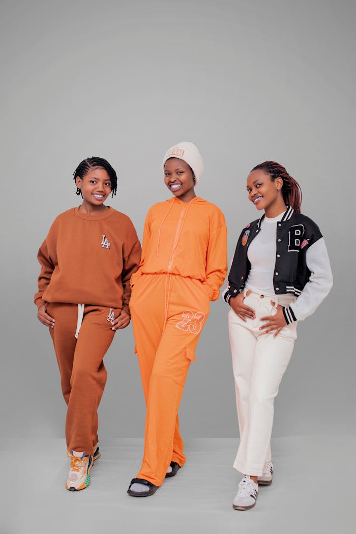 journey-01 Three young adults posing in stylish casual outfits with vibrant colors against a neutral backdrop.